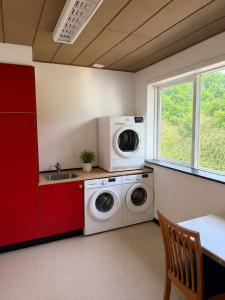 a laundry room with a washing machine and a sink at Room for rent Solskrænten in Vorgod