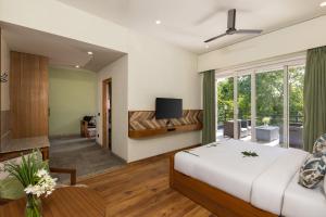a bedroom with a bed and a living room at The Golden Tusk By Ivory Destinations in Rāmnagar