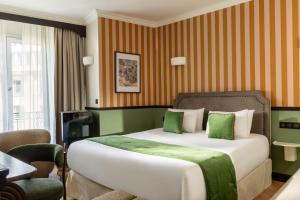 a bedroom with a bed with green and orange stripes at Hotel Du Flaneur in Paris