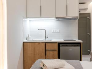 a kitchen with white cabinets and a sink at Pomelo Parga Cozy Studios in Parga