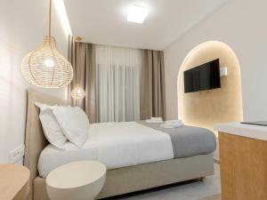 a hotel room with a bed and a tv at Pomelo Parga Cozy Studios in Parga