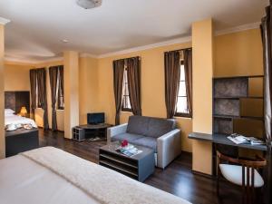 a hotel room with a bed and a couch at Effect Boutique Villa Azzura - Adults Only SELF CHECK-IN in Nesebar