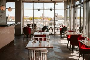 a restaurant with tables and chairs and large windows at Hotel Kossak in Krakow