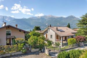 a house with a fence and mountains in the background at Colico Lake e Relax in Colico