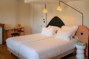 a bedroom with a large white bed with white pillows at Coureilles Appartements et Suites in La Rochelle