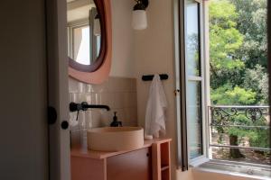 a bathroom with a sink and a mirror and a window at Coureilles Appartements et Suites in La Rochelle +120 photos