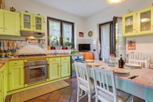 a kitchen with green cabinets and a table with chairs at Colico Lake e Relax in Colico