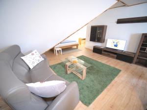 a living room with a couch and a television at Albsteig-Apartments Gruibingen in Gruibingen +9 photos
