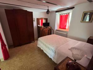 a bedroom with a white bed and a window at La casa di Mastro Ivetto in Arcevia