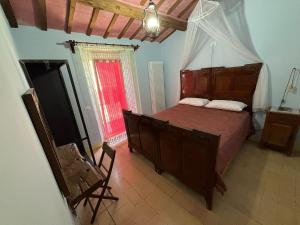 a bedroom with a bed and a chair in a room at La casa di Mastro Ivetto in Arcevia