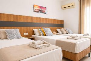 a bedroom with three beds with towels on them at Lecini Studios with Pool, by ZanteWize in Laganas +9 photos