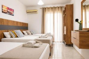 a hotel room with two beds and a dresser at Lecini Studios with Pool, by ZanteWize in Laganas
