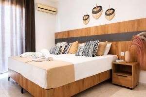 a bedroom with a large bed with a wooden headboard at Lecini Studios with Pool, by ZanteWize in Laganas
