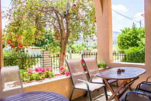 a table and chairs on a balcony with a tree at Philoxenia Hotel in Skala Prinou