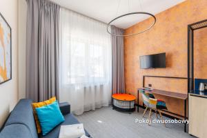 a living room with a blue couch and a desk at IND.U Apartamenty in Kołobrzeg
