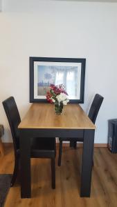 a dining room table with a vase of flowers on it at Studio Confort in Château-Chinon +7 photos
