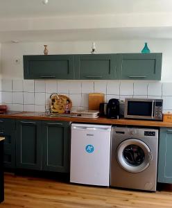 a kitchen with green cabinets and a washing machine at Studio Confort in Château-Chinon