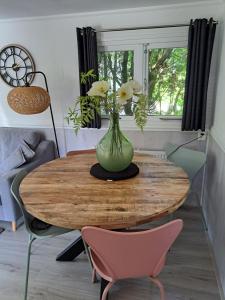 a vase with flowers on a wooden table in a room at Chalet Del Sole in Voorthuizen +11 photos