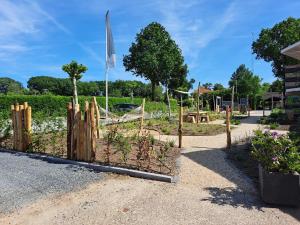 a garden with a fence and a playground at Chalet Del Sole in Voorthuizen