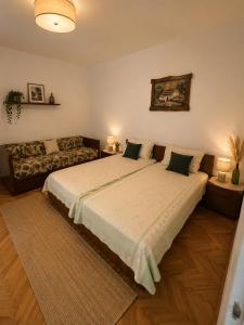 a bedroom with a large bed and a couch at House by the River in Orja Luka