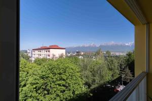 a view from a balcony of a building with trees and mountains at Tatra's View Apartment in Poprad