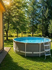 a bath tub sitting in the grass next to trees at House by the River in Orja Luka