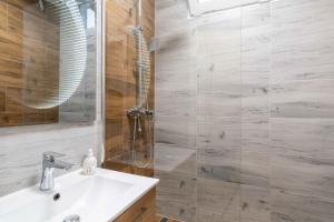 a bathroom with a shower with a sink and a mirror at Tatra's View Apartment in Poprad +7 photos