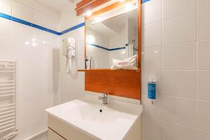 a bathroom with a sink and a mirror at Appart'City Classic Clermont Ferrand Centre in Clermont-Ferrand +34 photos