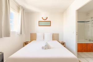 a white bedroom with a bed and a shower at Appart'City Classic Clermont Ferrand Centre in Clermont-Ferrand