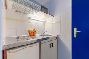 a small kitchen with a sink and a microwave at Appart'City Classic Clermont Ferrand Centre in Clermont-Ferrand