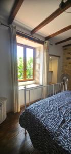 a bedroom with a bed and a window at Le Quereau in Saint-Macoux +19 photos