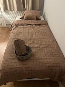 a bed with a blanket and a basket on it at Quarto single in Stykkishólmur