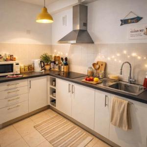 a kitchen with white cabinets and a sink at Rincon de Paz in Corralejo