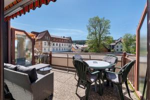 a patio with a table and chairs on a balcony at Schwarzwald Residenz Hirschen in Schönwald