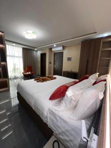 a bedroom with a large bed with red and white pillows at Teral Hotel by Fleur de Lys in Dakar