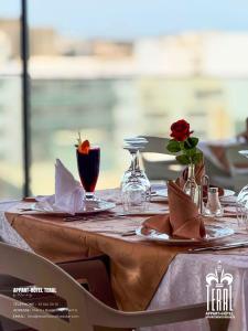a table with a white table cloth and a rose on it at Teral Hotel by Fleur de Lys in Dakar