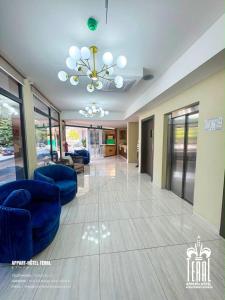 a living room with blue chairs and a chandelier at Teral Hotel by Fleur de Lys in Dakar