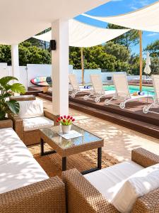 a patio with lounge chairs and a pool at Mercury Beach Hotel in SantʼAntìoco