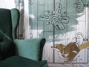 a drawing of a dog on a wall next to a chair at ibis Styles Kraków East in Krakow