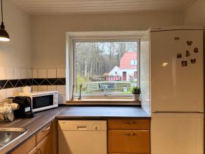 a kitchen with a white refrigerator and a window at Dream house in Glesborg