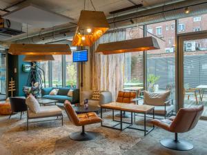 a lobby with chairs and tables in a building at ibis Styles Amiens Centre in Amiens