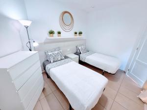 a white room with two beds and a mirror at Top Flor Ocean View in Playa del Cura