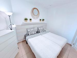 a white bedroom with a bed and a mirror at Top Flor Ocean View in Playa del Cura