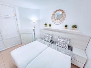 a white bedroom with a bed and a mirror at Top Flor Ocean View in Playa del Cura