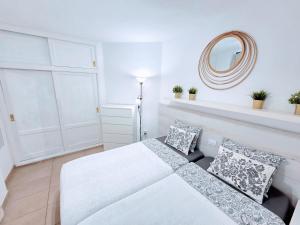 a white bedroom with a bed and a mirror at Top Flor Ocean View in Playa del Cura