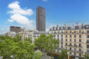 a view of a city with a tall building at Hôtel La Parizienne - Proche Montparnasse in Paris