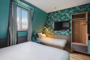 a hotel room with a bed and a tv at Hôtel La Parizienne - Proche Montparnasse in Paris