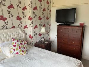 a bedroom with a bed and a television on a dresser at Solihull Twin Room Wi-fi, TV in Solihull