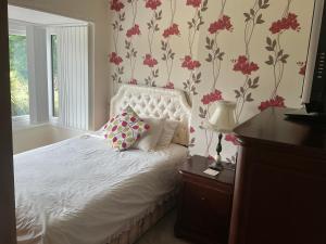 a bedroom with a white bed with pink flowers on the wall at Solihull Twin Room Wi-fi, TV in Solihull