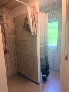 ein Badezimmer mit Dusche und Duschvorhang in der Unterkunft Room for rent Landsbyen in Videbæk